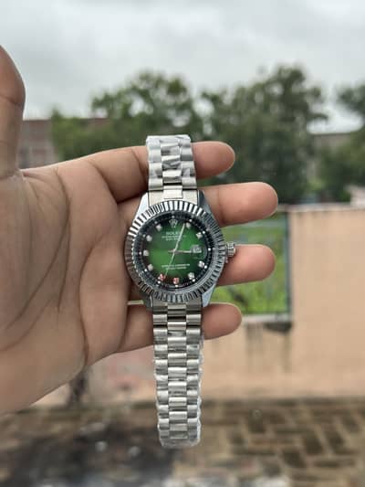Rolex watch silver chain strap green dail