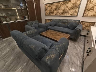 blue sofas with golden shade with an glass table