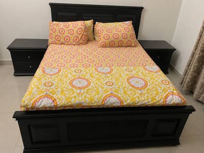 Wooden queen sized bed with two bedside tables