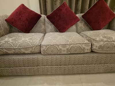 10 seater sofa set with maroon cushions and 2 side tables.