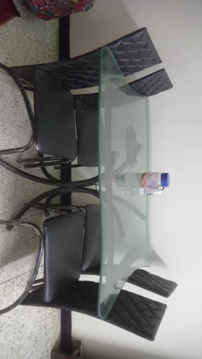 glas top iron dining table with four chairs.