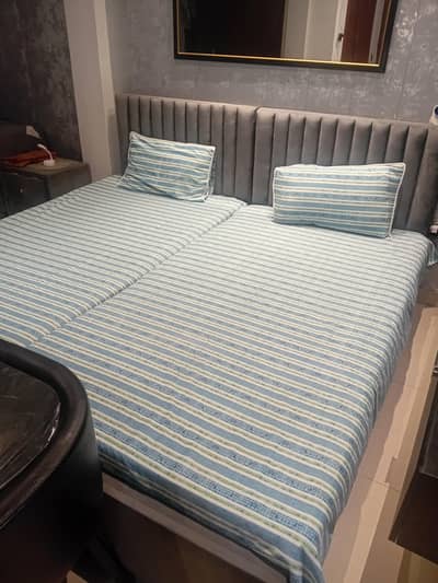 2 single beds with one center table and mattresses