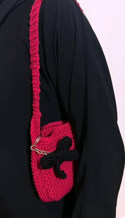 handmade crochet bag with black bow detail. . .