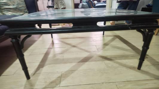 glass table with black wooden skeleton
