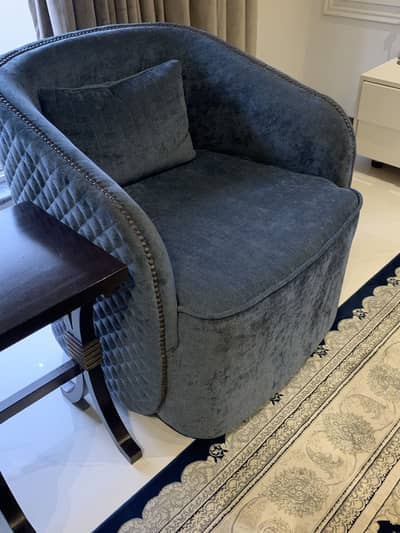 A wooden mate textured clth chair with the wooden circle studs