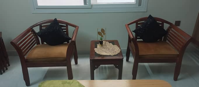 2 sofa chairs full wooden with table and glass without cushions.