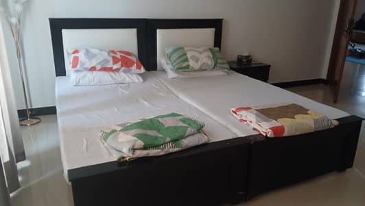 Two high quality wooden single beds + 1 sidetable
