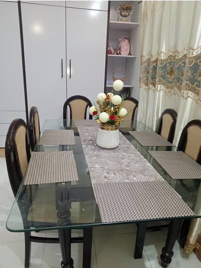 beautiful glass dinning table with six chairs in skin mustard colour.