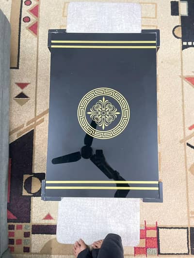 brown center table with top glass golden pattern and wooden legs