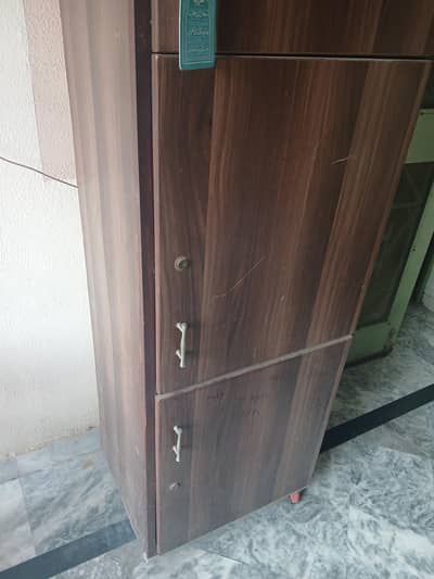Wooden Almirah containing 3 storage racks each seperated more inside.
