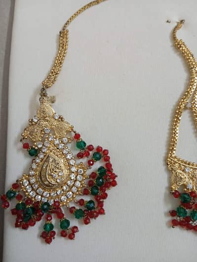 red and green golden set with white stone