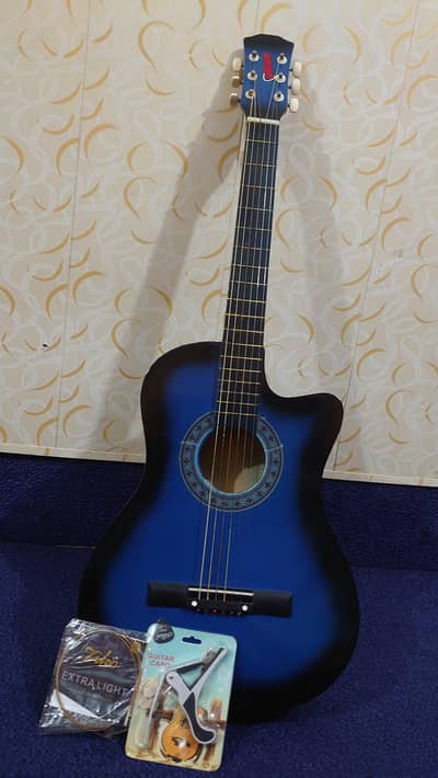 Royal blue acoustic guitar with one sting extra and capo and pick