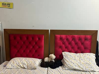 Pair of single beds with red cushioning