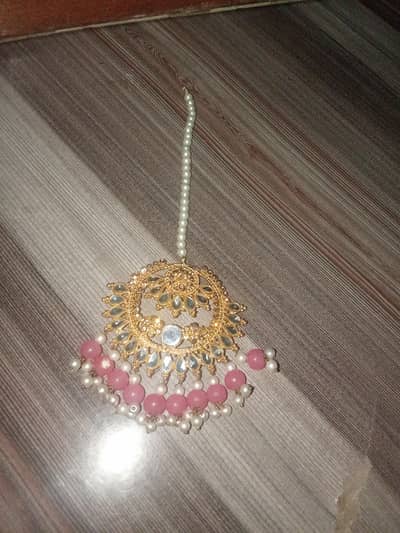 Elegent golden colour tikka with light pink and white pears