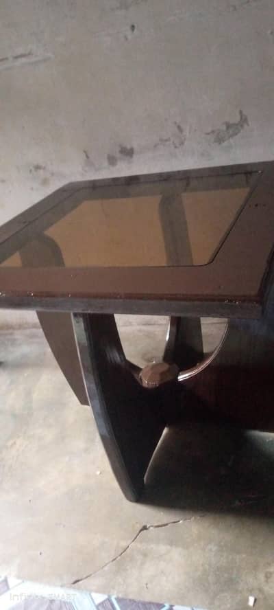 Wooden table with dark brown glass