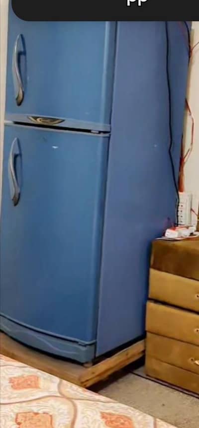 blue colour orient small sized fridge with stabiliser and wooden stand