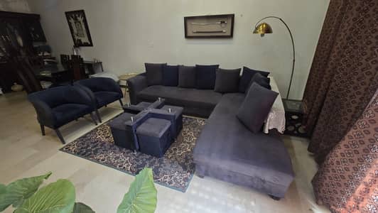 L shaped sofa with 2 extra chairs and a center table with 4 stools