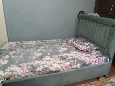 single bed with gray Turkish cover