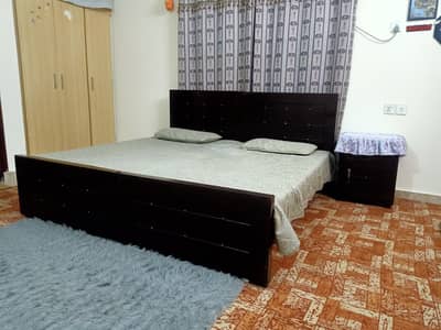 A pair of wooden single beds with mattress