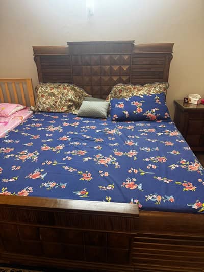 sold wood bed set with room chair and table.