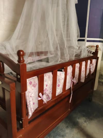 Wooden baby cot with mosquitos net