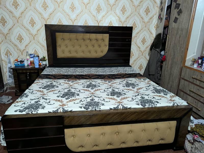 large size bed with a side table. 0