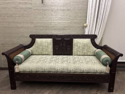 Antique style hand carved with green upholstery and bolster pillows