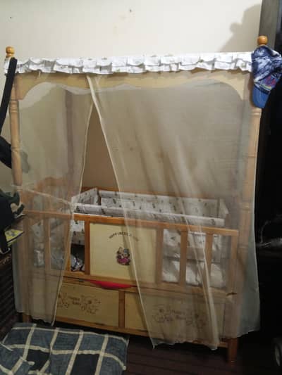 wooden baby crip bed with storage draws.