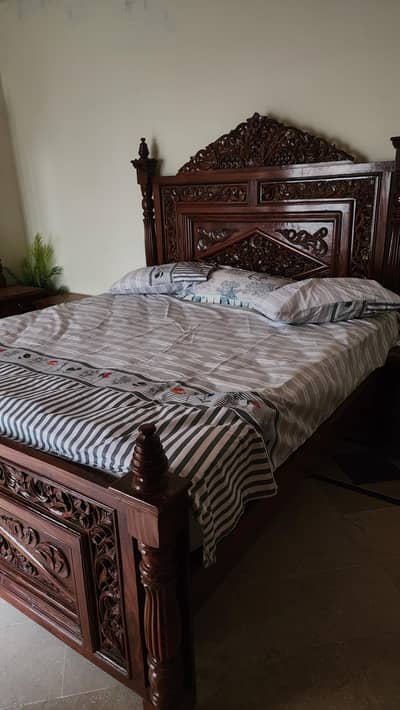 traditional wooden bed with side tables and dresser