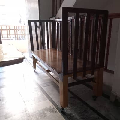 Baby side bed with full wooden and tyres with lavish paint .