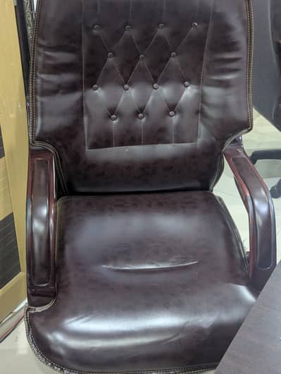 A classic high-back executive chair upholstered in a dark brown leath