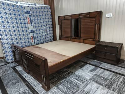 King size bed with mattress and side table.