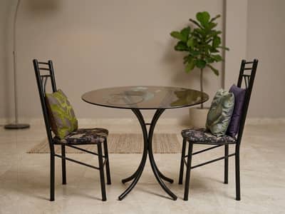 iron bed with 2 chairs and table