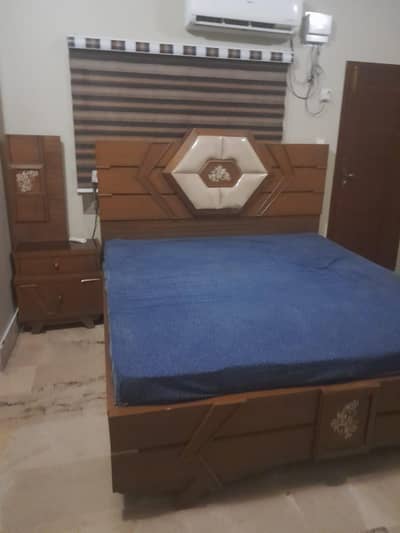 wooden bed with one side table two cupboard and dressing table