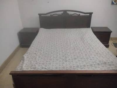 wooden bed with mattress and two side tables
