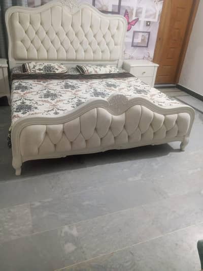 one wooden bed with side table and dressing