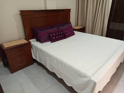 king size wooden bed with side tables