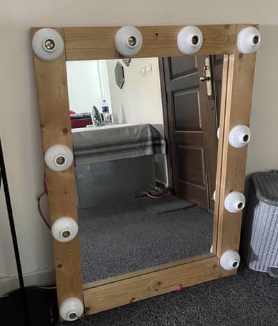 Wooden mirror with light bulbs.