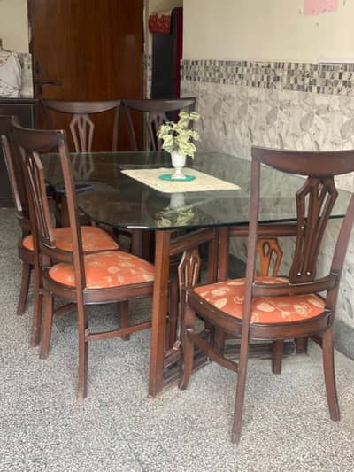Big wooden dining table with heavy glass top