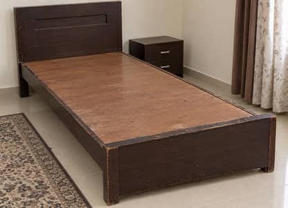 two wooden single beds without mattresses