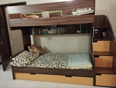 Interwood kids bunk bed with drawers in the stairs and book shelves .