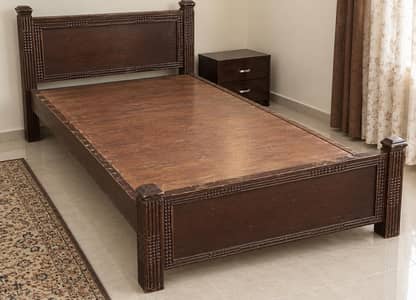 two wooden single beds without mattresses