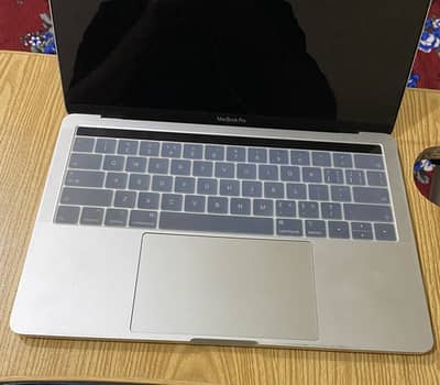 MacBook Pro 2019 model with original charger and covers