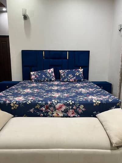 bed with two side table and two seater sofa