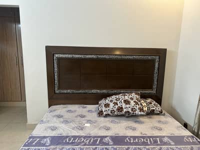 dark brown wooden panel bed with a high headboard