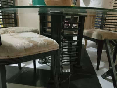 wooden chairs and glass top dining table