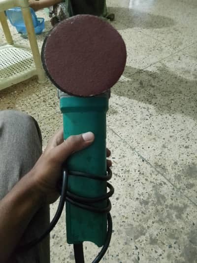 4-inch (100mm) electric angle grinder fitted with a sanding disc.
